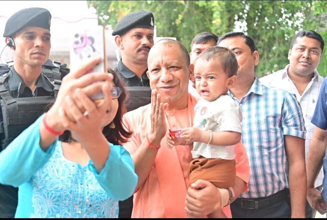 मुस्कुराते हुए मुख्यमंत्री योगी आदित्यनाथ की गोद में है रोता हुआ बच्चा